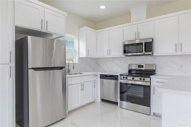 Kitchen with Stainless Steel Appliances, Quarz Counter-tops, White Wood Cabinets.