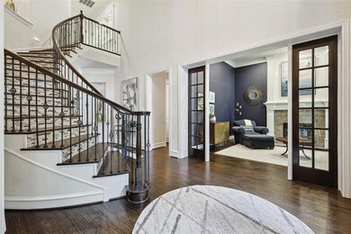 Entrance foyer featuring french doors, dark wood- floors, and a high ceiling- exudes plenty of natural light.
