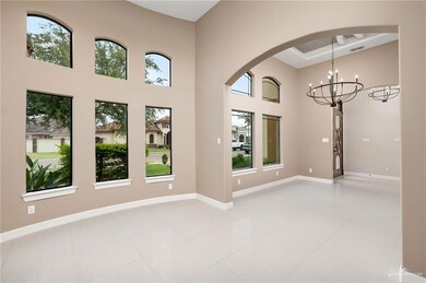 Spare room with light tile patterned flooring, a high ceiling, and a chandelier