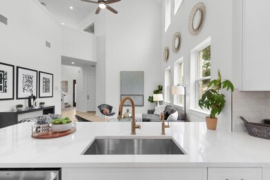 Kitchen featuring a high ceiling, white cabinetry