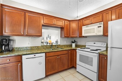 Kitchen featuring a sink, a textured ceiling, whit