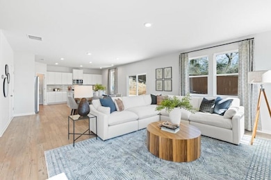 Living room featuring light wood-style floors, recessed lighting, and baseboards