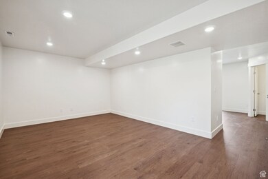 Basement featuring recessed lighting and dark wood-style floors