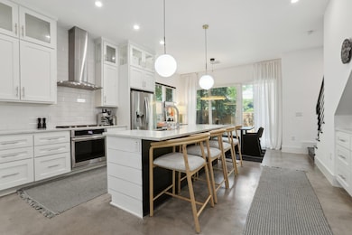 Kitchen with wall chimney range hood, stainless s