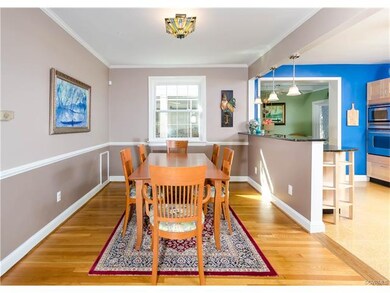 The dining room has hardwood flooring, crown and c