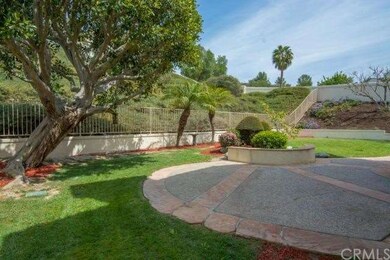 This peaceful backyard has mature manicured trees 