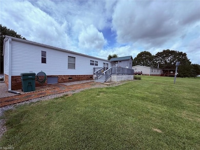 View of back of home w/deck and additional storage room.