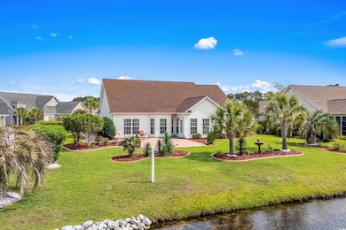 Back of property featuring a patio area, a yard, and a water view