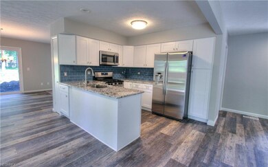 OPEN KITCHEN WITH GRANITE COUNTERS AND NEVER BEEN USED STAINLESS STEEL APPLIANCES