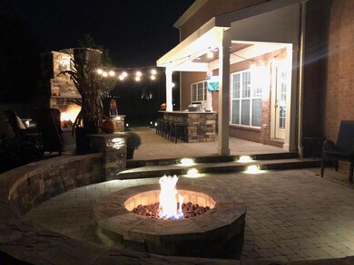 A nighttime photo with fire pit, string lights, and fireplace roaring!