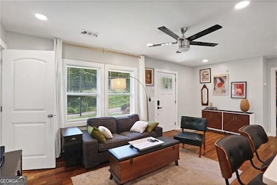 Living room with a ceiling fan, wood finished floors, and recessed lighting