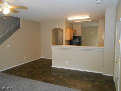 Kitchen featuring dark wood-type flooring, freestanding refrigerator, light countertops, and a peninsula
