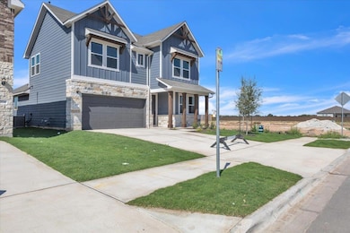 Craftsman-style home featuring stone siding, a front lawn, driveway, and a garage