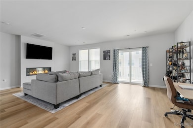 Living area featuring baseboards, visible vents, a