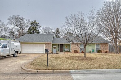 Ranch-style home with a front lawn and a garage
