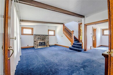 Large windows, a wood burning fireplace, and original woodwork in the living room