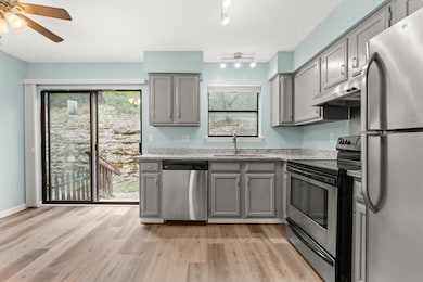 Kitchen with stainless steel appliances, gray cab