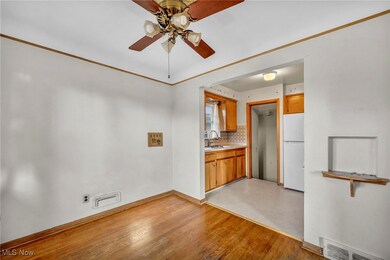 Unfurnished dining area featuring light wood finished floors, a ceiling fan, and crown molding