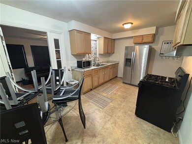 Kitchen with backsplash, sink, appliances with stainless steel finishes, and light tile flooring