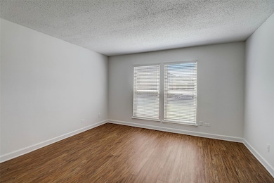 Empty room with hardwood / wood-style floors and a