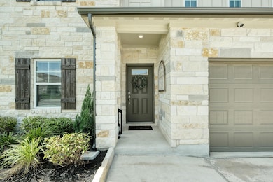 View of exterior entry featuring a garage and sto