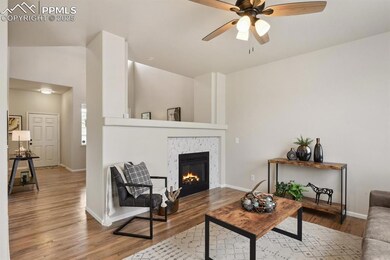 Living area with a ceiling fan, wood finished floo