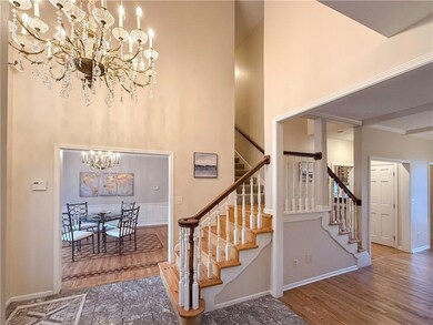 Stairs featuring wood-type flooring, a high ceiling, and an inviting chandelier