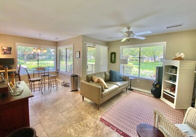 Tiled living room with ceiling fan with notable ch