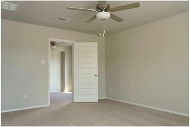 Empty room with a ceiling fan and light carpet