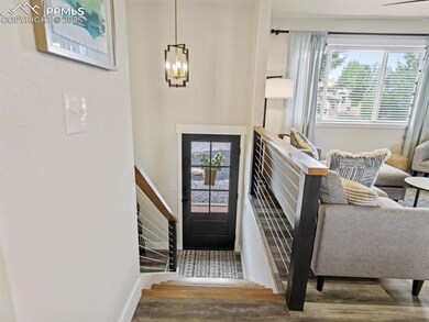 Entryway with healthy amount of natural light, wood finished floors, and a chandelier