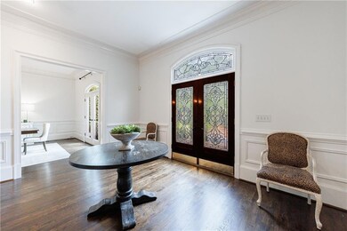 Entryway with plenty of natural light, crown molding, wood finished floors, and french doors