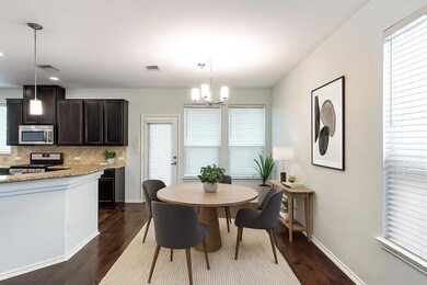 Dining area with dark wood-type flooring and a chandelier