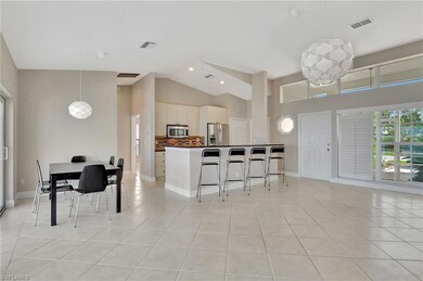 Kitchen with a kitchen bar, white cabinets, light 