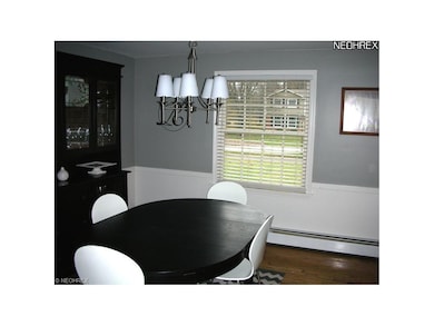 Formal dining room with wood flooring and chandeli