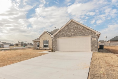French provincial home featuring concrete driveway, a garage, stone siding, and brick siding