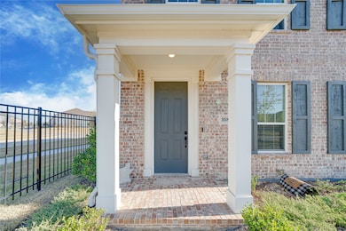 Doorway to property featuring brick siding and a porch
