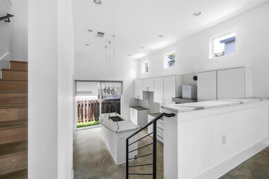 Kitchen with white cabinetry, a high ceiling, a s
