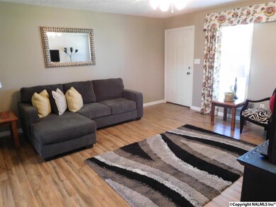 The family room with new laminate wood floors, new ceiling fan, window treatments, and fresh paint. This home home has been completely updates and every room has plenty of sun light.