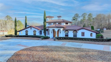 Mediterranean / spanish-style house with stucco siding, curved driveway, a tile roof, and fence