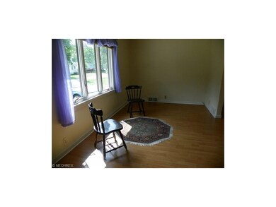 Bright and cherry living room  with newer laminate floor  and large front window with view of street