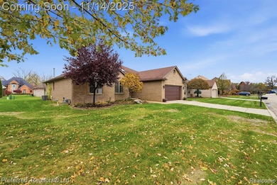 View of front of property with driveway, a front yard, brick siding, and an attached garage