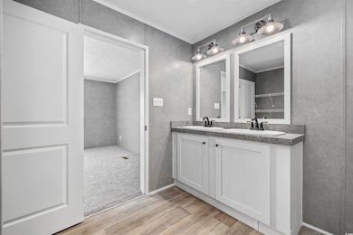 Bathroom with double vanity and wood finished floors