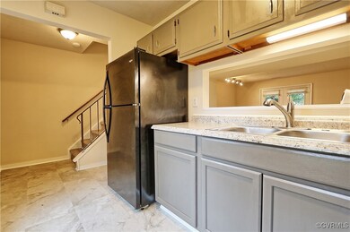 Kitchen with gray cabinetry, sink, and black refrigerator