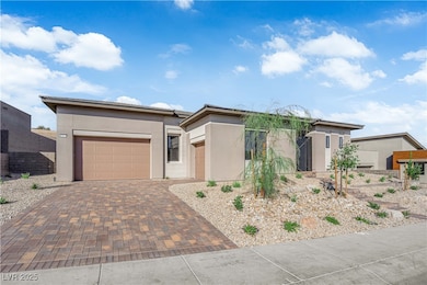 Prairie-style house featuring decorative driveway, stucco siding, an attached garage, and a tile roof