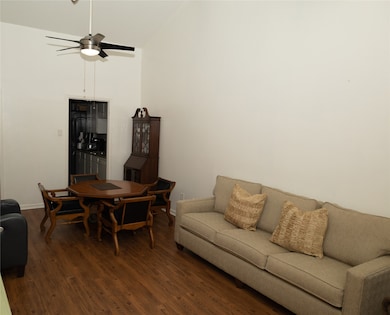 Living area featuring wood finished floors, ceiling fan, and high vaulted ceiling