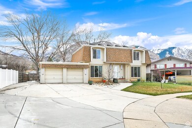 View of front facade with a mountain view, brick siding, concrete driveway, a shingled roof, and mansard roof