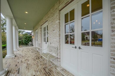 Covered front porch,  double doors, brick flooring and bead board ceiling.