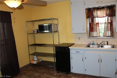Kitchen featuring sink, tasteful backsplash, and ceiling fan