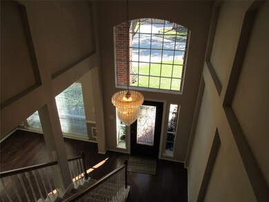 Taken from upstairs landing, second floor game room is open to both the front and back of home. Overlooking family room and gorgeous pool & spa!