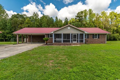 Single story home with a front yard, a sunroom, an
